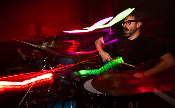 Energetic drummer performance with dynamic light effects