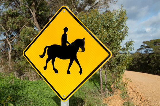 Warning sign indicating that horses and riders may share the road.