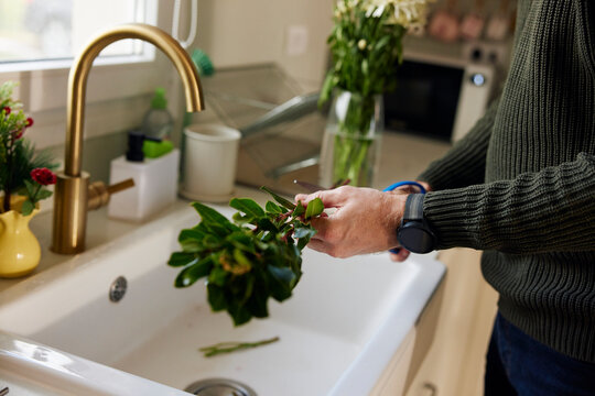 Man arranges flowers in the kitchen