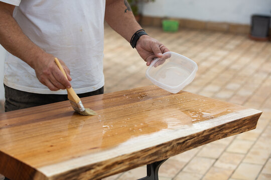 Carpenter applies wood preservative
