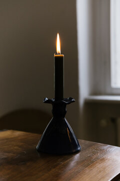 Burning Candle in Ceramic Holder