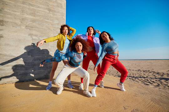 Group of diverse girlfriends dancing on beach