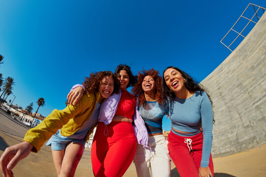 Cheerful diverse friends walking on street