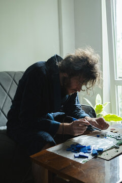 Man brazing wax models at home