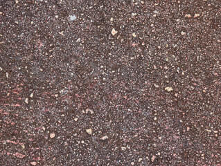 Top view and close-up of worn eroded asphalt tennis court floor with red paint and moisture, decolored hard outdoor surface texture or background.	