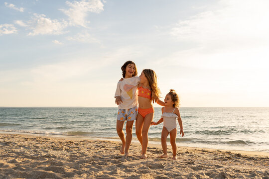 Siblings playing at the beach at golden hours