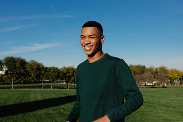 Cheerful healthy young man enjoys a sunny morning in a park in Madrid