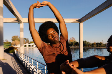 Fit friends perform mindfulness breathing after a morning workout