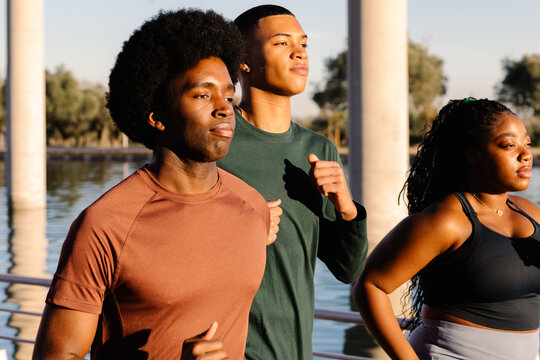 Fit young individuals run together, easing into a cooldown session
