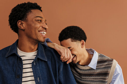 Men laughing together in brown background