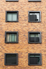 details of brick residential building, with square windows, texture of the facade of residential area, architecture and design