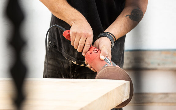Detail of carpenter's hands using power tool.