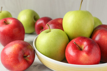 Ripe red and green apples on white marble table, closeup