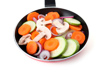 Frying pan with mix of fresh vegetables and mushrooms isolated on white