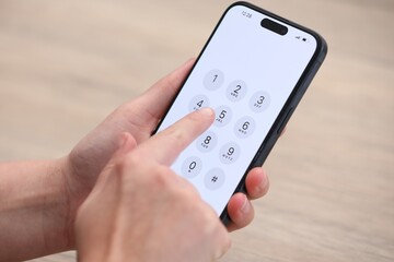 Woman dialing number on smartphone against blurred background, closeup