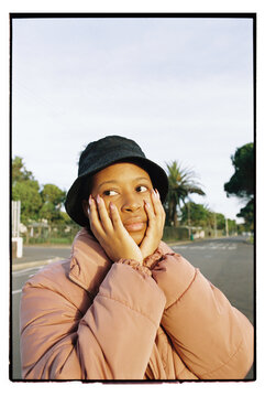 Portrait of African woman wearing a pink puffer jacket at golden hour