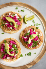 REFRIED BEAN AND PICKLED RED CABBAGE TOSTADAS with fresh cilantro, avocado and lime juice