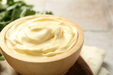 Delicious mayonnaise sauce in bowl on table, closeup