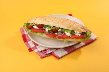 Delicious baguette with salmon on yellow background