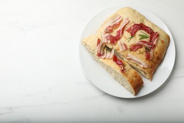 Pieces of delicious focaccia bread with bacon and rosemary on white marble table, top view. Space for text