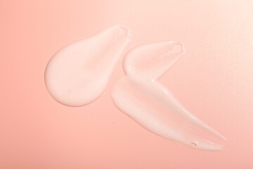 Cream samples on pink background, top view
