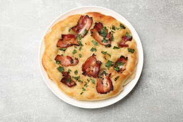 Delicious focaccia bread with bacon and parsley on light grey table, top view