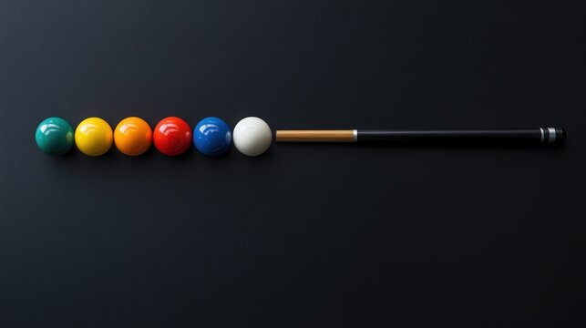 Colorful billiard balls in a row with cue stick on dark background.