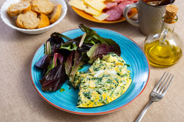 Homemade continental hearty breakfast - omelette with spinach, several slices of bran bread, cheese and sausage