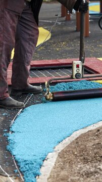 Installation of Blue Rubber Coating. Construction Process for Playgrounds and Sports Grounds