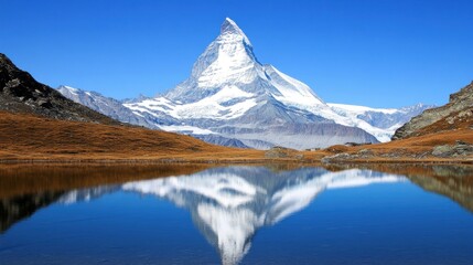 Naklejka premium Majestic mountain reflected in a serene lake under a clear sky.