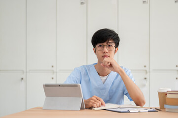 A smart Asian male medical student is focused on listening to a professor teaching in the classroom.
