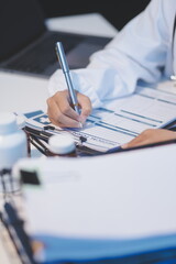 Doctor sitting at desk and writing a prescription for her patient