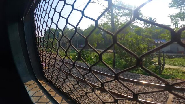 POV of a passenger in a local EMU train traveling through a suburban area outside Kolkata