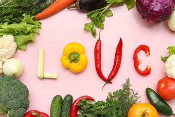 Composition with word LOVE, fresh vegetables and herbs on pink background