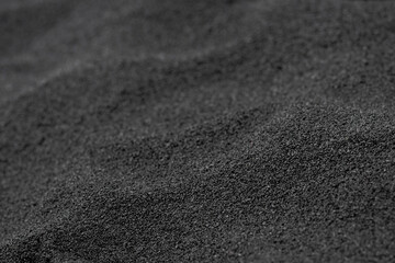 Unique and beautiful black volcanic sand made of lava on the ocean beach. Black sand beach, Big Island, Hawaii, USA.