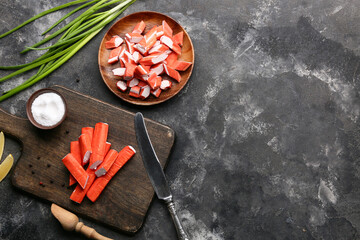 Wooden board and plate with tasty crab sticks on black background © Pixel-Shot
