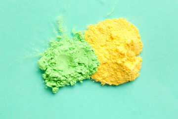 Heaps of color powder pigments on turquoise background