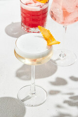 Classic cocktail - pisco sour with egg foam on elegant glass. Pisco sour on white background with shadows. Lifestyle summer drink menu. Sour cocktail with citrus and foam. Aesthetic alcohol drink.