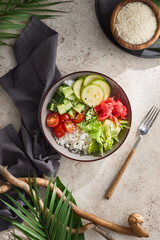 Vegetarian poke bowl on light background with shadows and wooden elements. Poke bowl with rice and vegetables on natural backdrop. Aesthetic vegan food. Ahi poke veggie in summer day bali style.