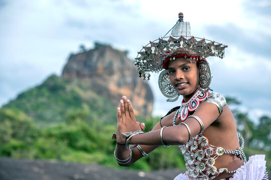 SIGIRIYA, SRI LANKA - JULY 16, 2024 : A Ves Dancer, also known as a Kandyan Dancer or Up Country Dancer performs at Sigiriya in Sri Lanka. In the background stands Sigiriya Rock.