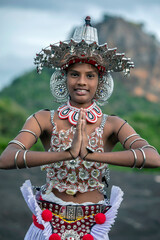 SIGIRIYA, SRI LANKA - JULY 16, 2024 : A Ves Dancer, also known as a Kandyan Dancer or Up Country Dancer performs at Sigiriya in Sri Lanka. In the background stands Sigiriya Rock.
