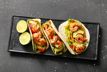 Tray with fresh tasty tacos on black speckled background