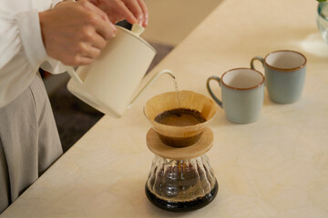 コーヒーを淹れる中年の女性　夜のリビング　顔無し