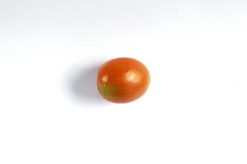 A tomato on a white background. Tomatoes, or Solanum lycopersicum, are a seasonal fruit of the Solanaceae family native to Central and South America. It has a sour and slightly sweet flavor.