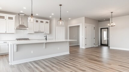 Fototapeta premium Bright kitchen with island, hardwood floors, and white cabinets.