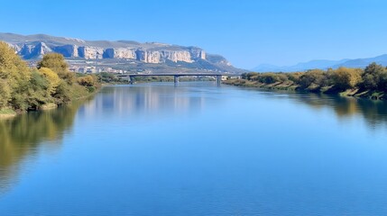 Obraz premium Serene Autumn River Photo: Wide Shot of Calm Waters Reflecting Majestic Mountains. AI Generated
