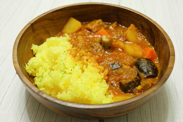 Delicious looking curry with lots of vegetables, yellow saffron rice, steam