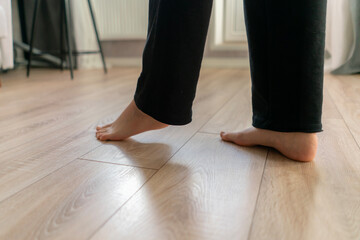 Barefoot walking on warm wooden flooring provides comfort and relaxation in a cozy interior space during a peaceful day