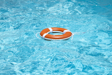 Rescue swimming ring. Drowning concept. No swimming. Safety water equipment. Lifebelt on sea or pool. Inflatable ring floating in blue water.