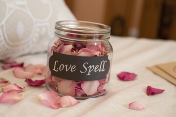 rose petal in glass jar for love spell on bed